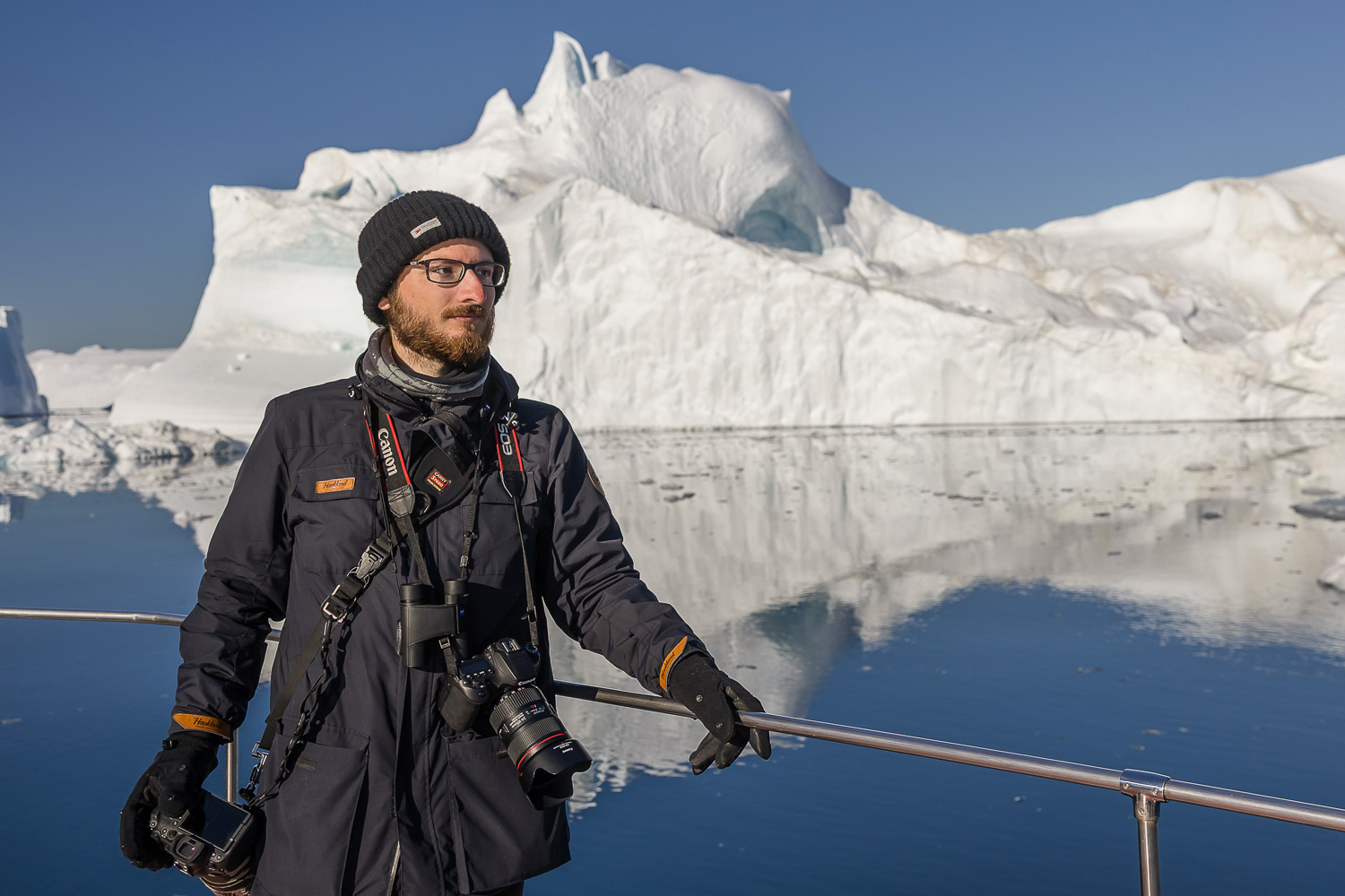 Teilnehmer einer Grönland-Fotoreise auf einem Boot vor großen Eisbergen in der Diskobucht