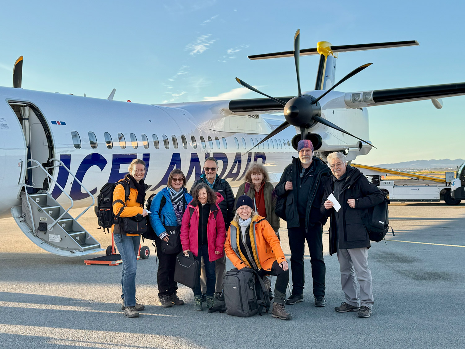 Fotografin Radmila Dier mit Reisegruppe vor Icelandair-Propellerflugzeug – Start der Fotoreise in Island