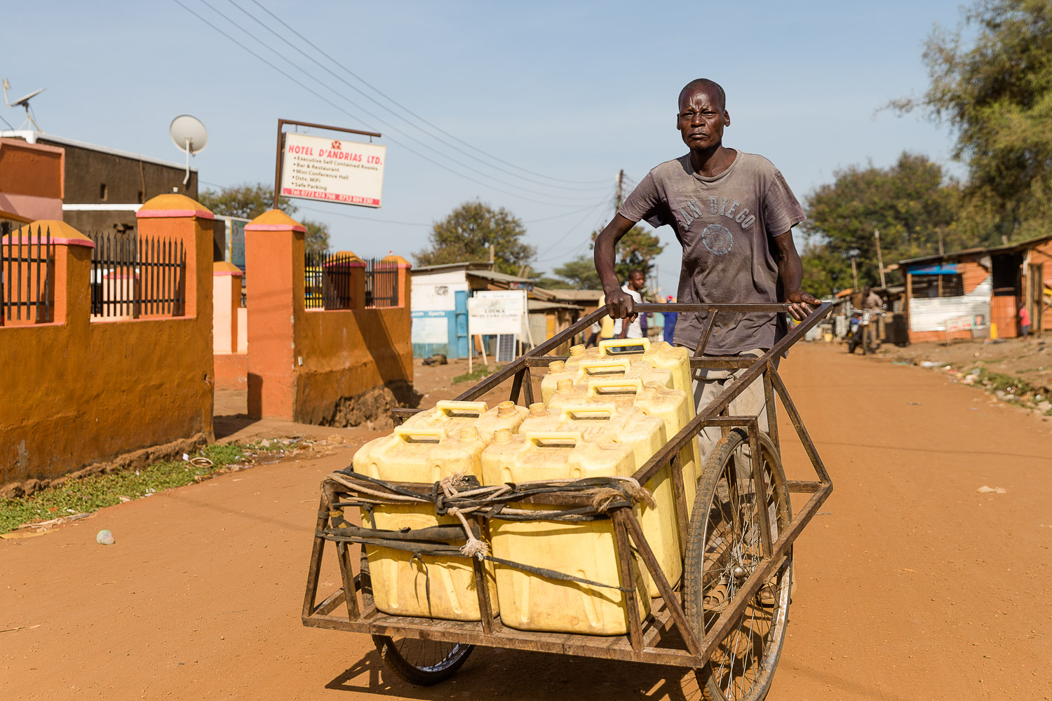 Mann mit Wasserkanistern auf einer Straße in Moroto in Karamoja, Uganda