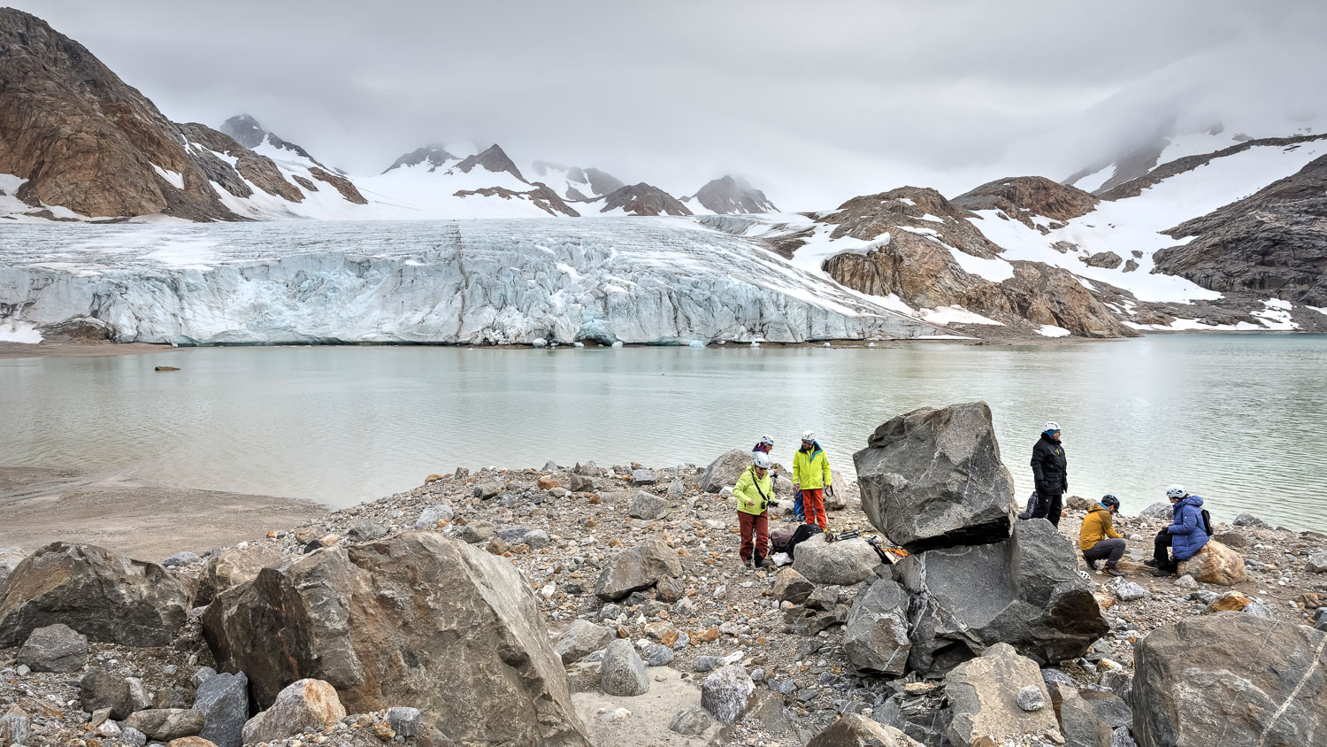 Am Apusiaq-Gletscher in Ostgrönland Fotogruppe am Apusiaq-Gletscher mit Gletschersee und verschneiten Bergen in Ostgrönland Foto: Radmila Dier