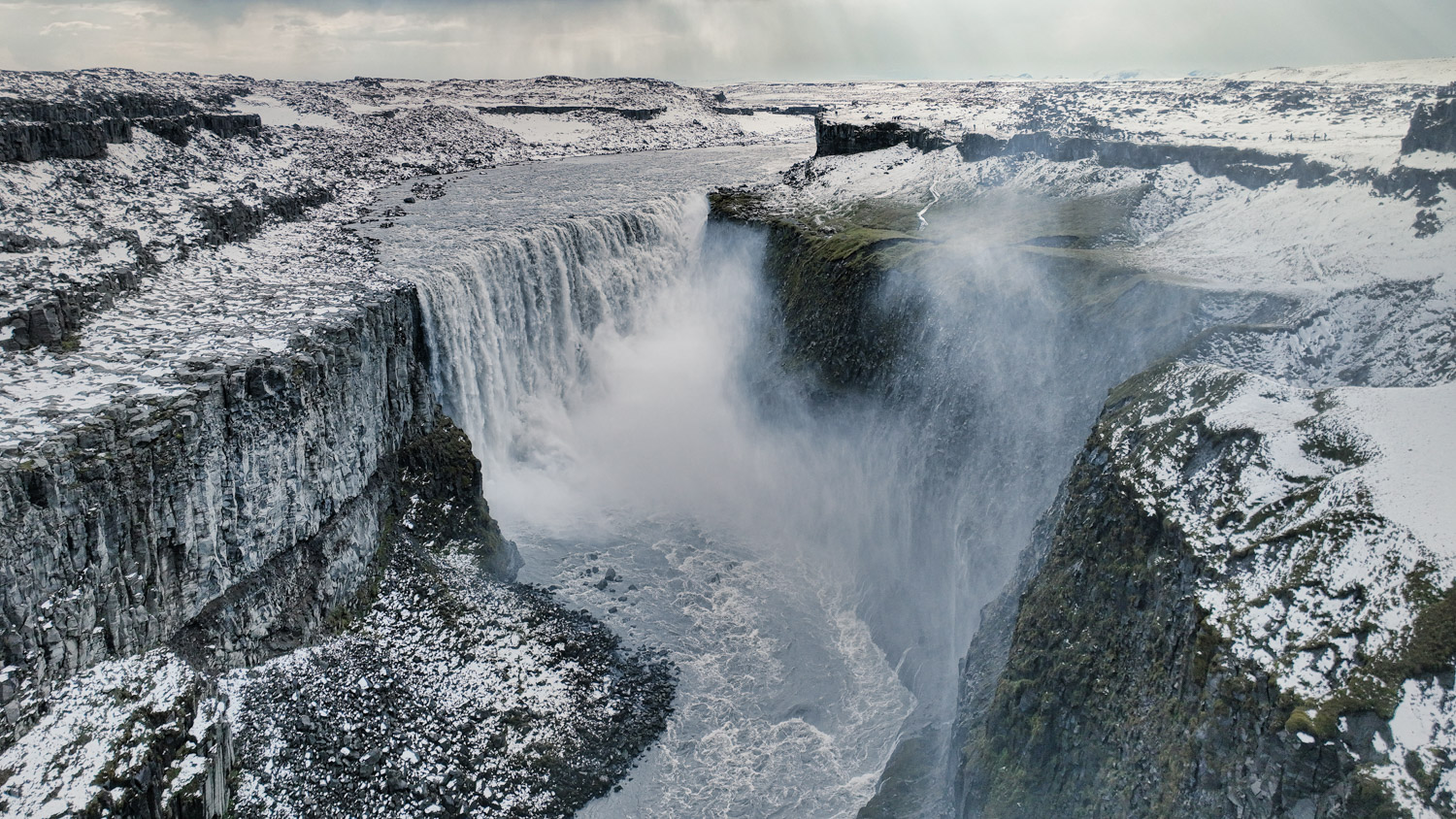Dettifoss im Winter – Drohnenaufnahme über dem mächtigen Wasserfall in Nordisland Dettifoss Wasserfall im Winter aus der Luft mit Schnee, Gischt und Canyon im Norden Islands