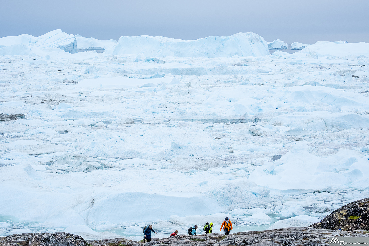 Kleine Gruppe von Fotografen vor einer gewaltigen Eislandschaft in Grönland