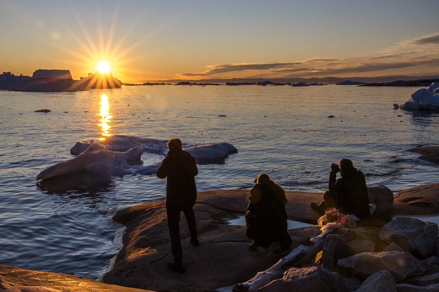 Fotografen bei Abendlicht zwischen Eisbergen in der Diskobucht in Grönland