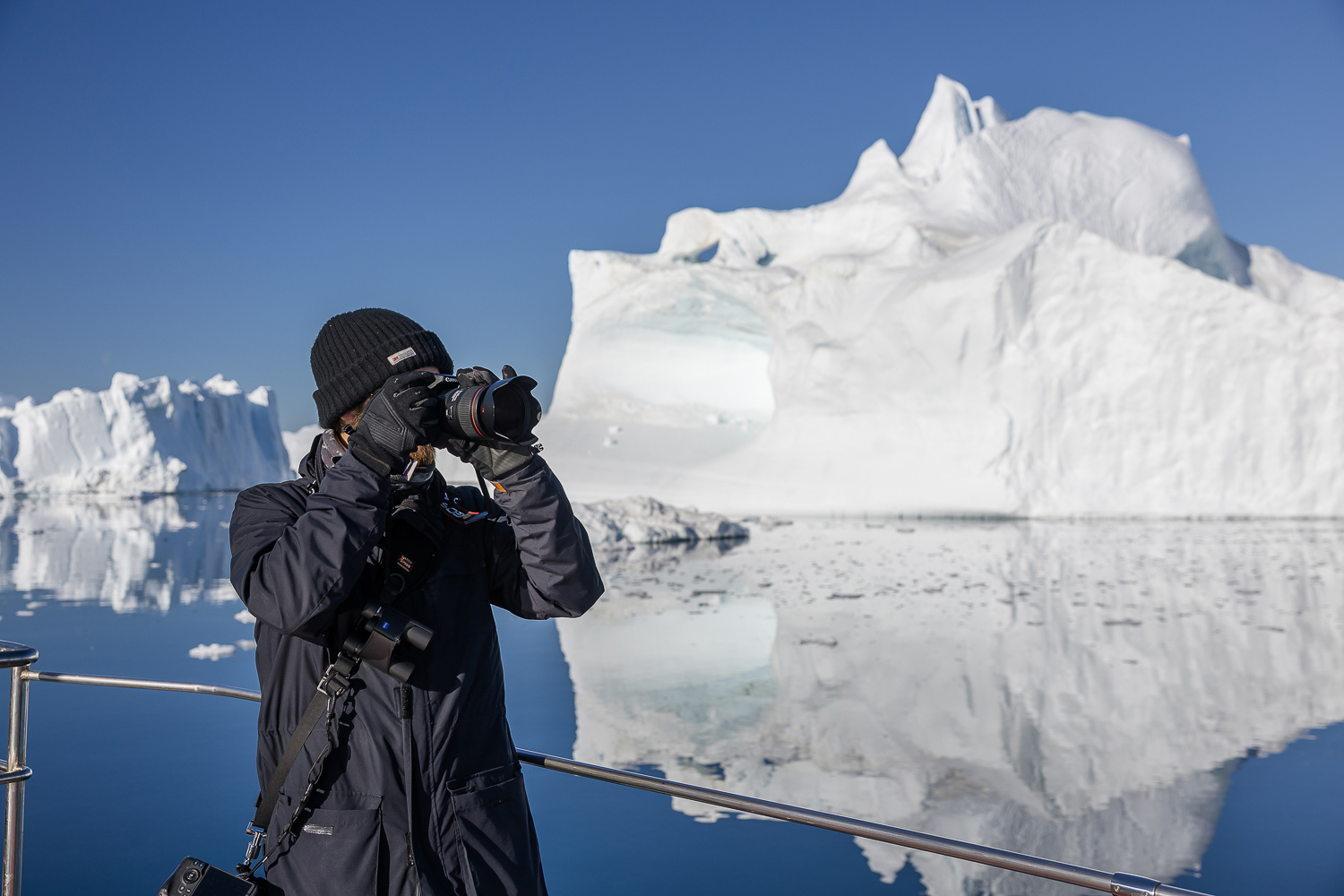 Fotograf auf einer Grönland-Fotoreise vor einem großen Eisberg in der Diskobucht
