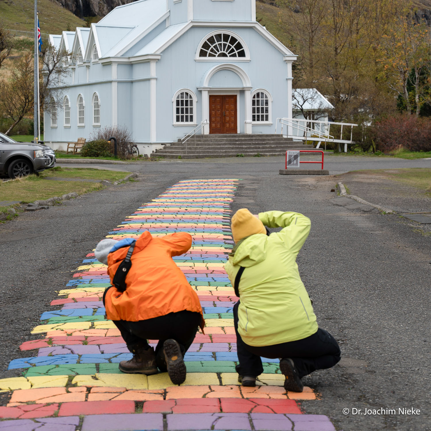 Fotoreise in Seyðisfjörður in Island Teilnehmer einer Fotoreise fotografieren die Regenbogenstraße vor der blauen Kirche in Seyðisfjörður in Island
