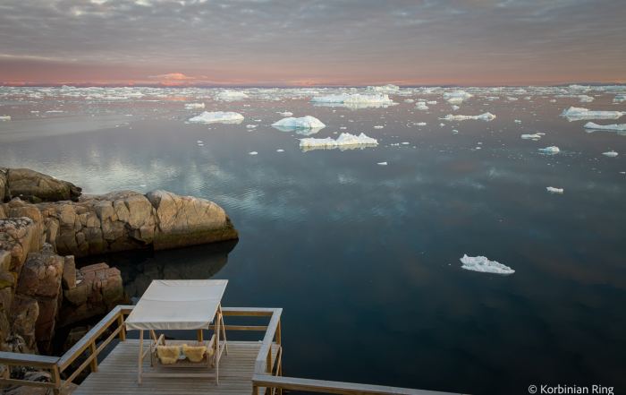 Hotelterrasse mit Schaukel und Blick auf Eisberge in der Diskobucht bei Ilulissat