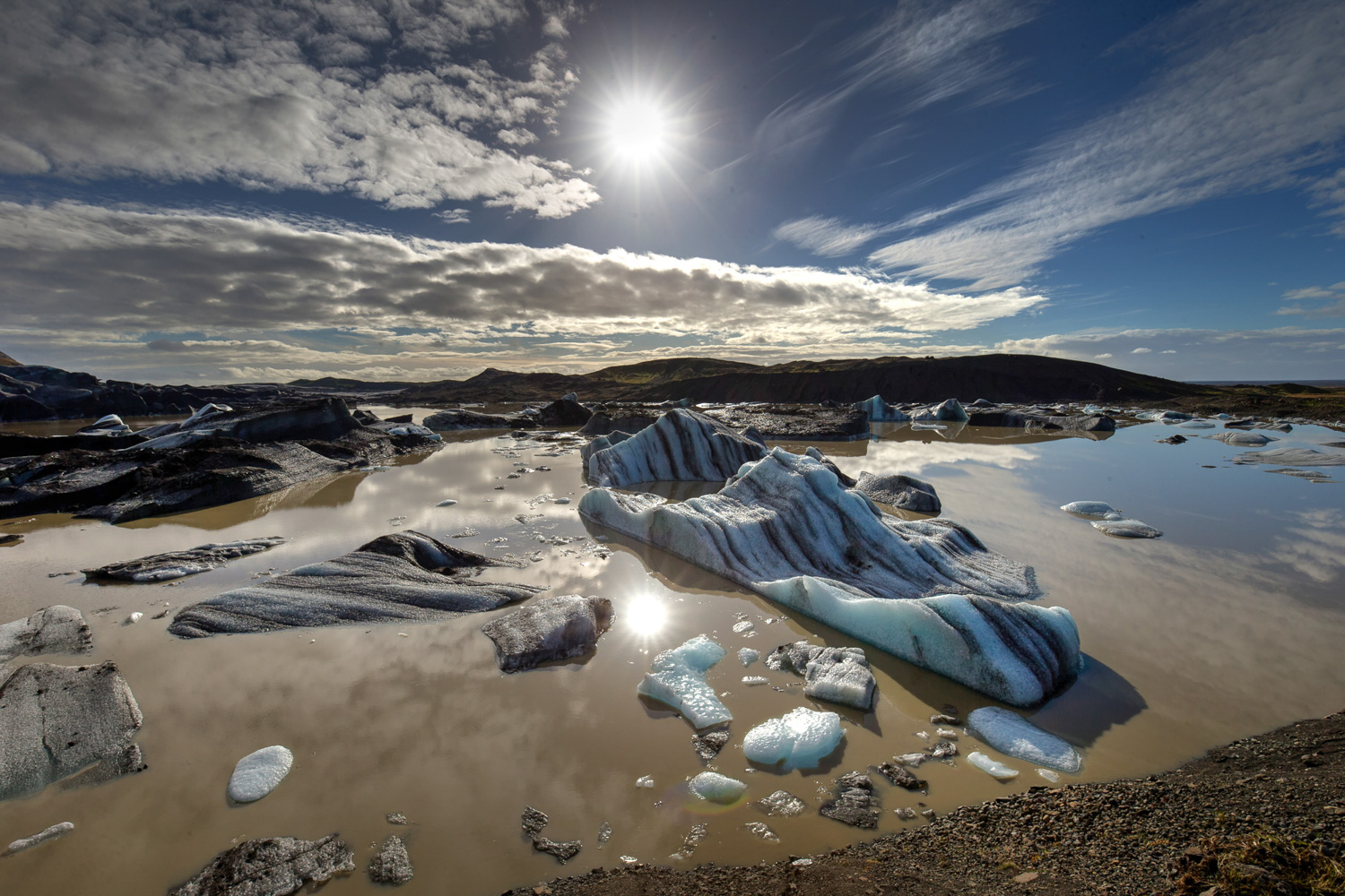 Gletscherlagune in Südisland – Drohnenfotografie in geschützten Gebieten Gletscherlagune mit Eisbergen und Auslassgletscher im Süden Islands unter blauem Himmel