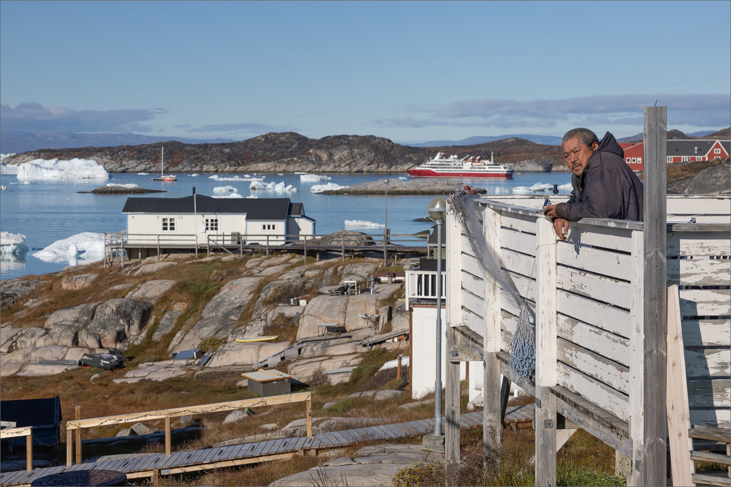 Einheimischer in Ilulissat blickt auf den Ilulissat Eisfjord und die Diskobucht während einer Fotoreise nach Grönland