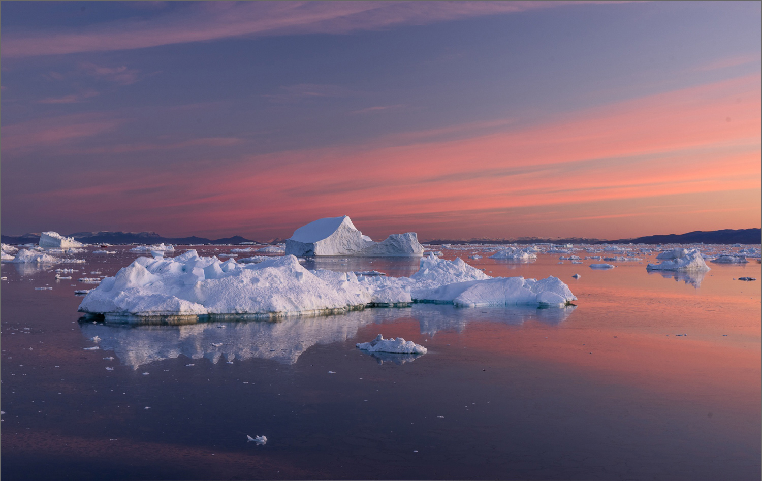 Morgenstimmung in der Diskobucht kurz vor Sonnenaufgang mit Eisbergen, Blick von der Hotelterrasse in Ilulissat während einer Fotoreise nach Grönland