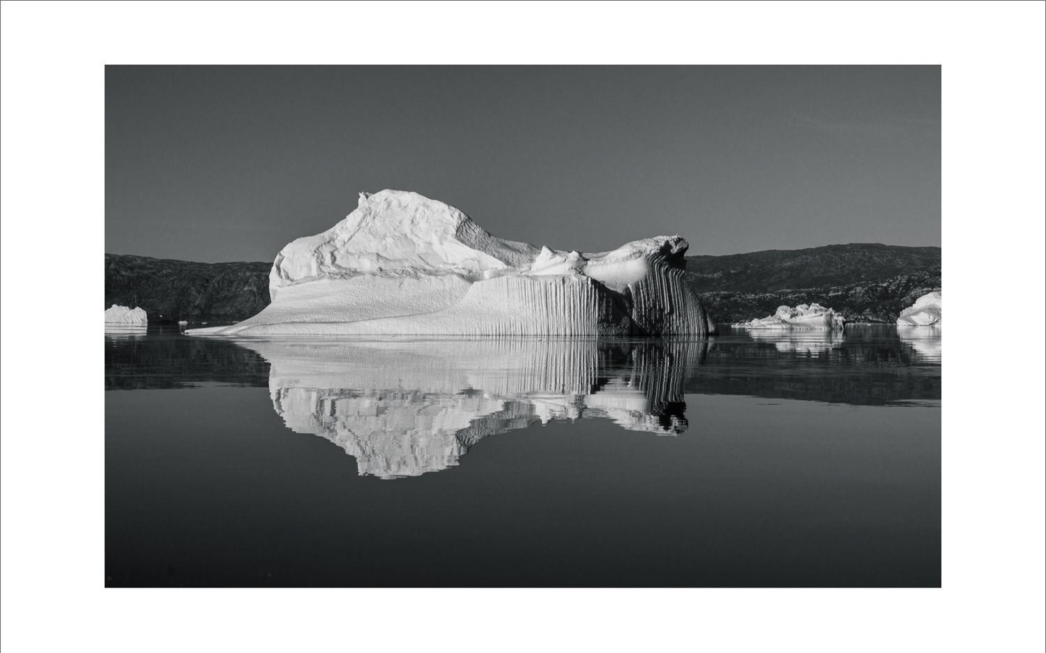 Schwarz-weiß Fotografie eines Eisbergs mit Spiegelung in der Diskobucht bei Ilulissat, Westgrönland