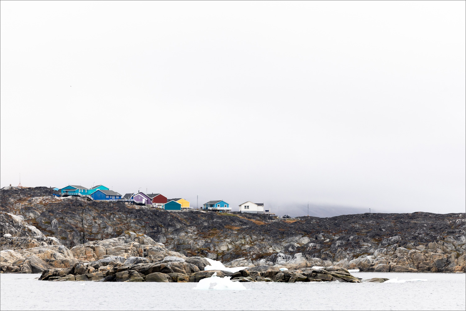 Bunte Häuser von Qeqertarsuaq auf der Disko-Insel an der Diskobucht in Westgrönland, fotografiert vom Meer aus