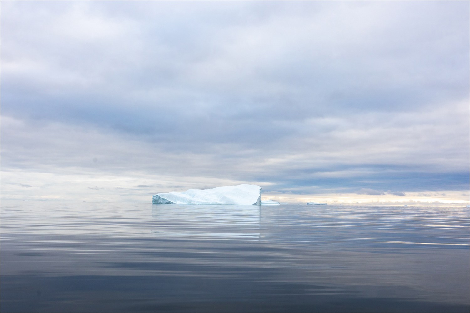 Eisberg in der Diskobucht am späten Nachmittag, ruhige See und arktisches Licht in Westgrönland