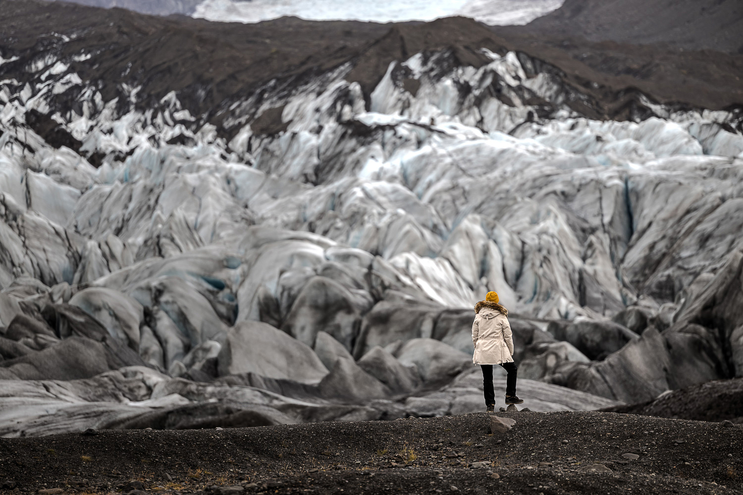 Gletscherzunge in Island fotografieren Gletscherzunge in Island mit Wanderer vor dunklen Ablagerungen aus Vulkanasche und Gesteinsmehl Foto: Radmila Dier