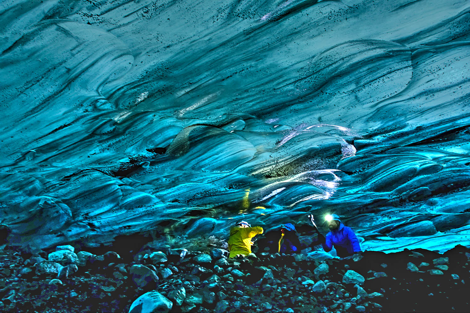 Island Gletscherhöhle: Fotografen mit Stativen unter Eisdecke Mehrere Fotografen mit Stativen in einer isländischen Gletscherhöhle unter niedriger, blau schimmernder Eisdecke.
