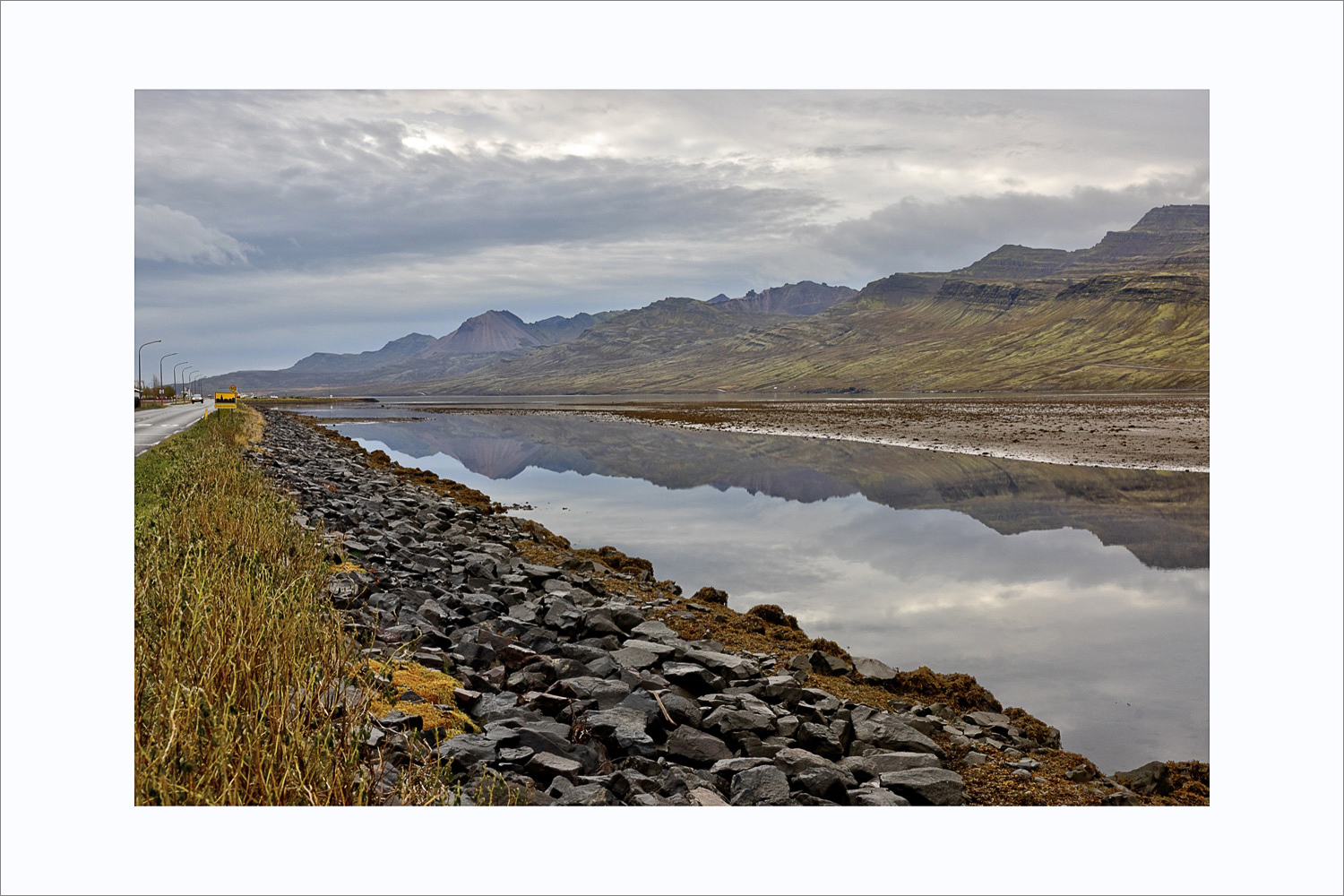 Fjordlandschaft mit Spiegelung im ruhigen Wasser bei Fáskrúðsfjörður in den Ostfjorden Islands