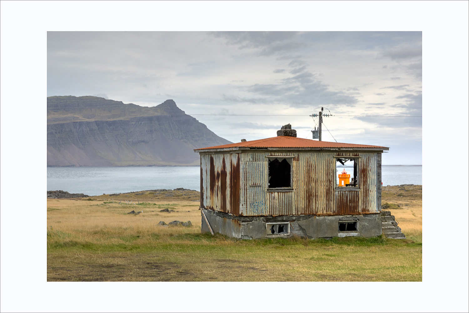 Verlassenes rostiges Haus am Fjord in den Ostfjorden Islands