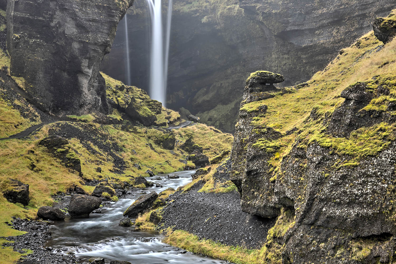 Wasserfall im Moos-Canyon Island – Langzeitbelichtung mit Fluss Langzeitbelichtung in Island: Wasserfall im Canyon, moosbedeckte Felsen und ein Fluss als Leading Line im Vordergrund.