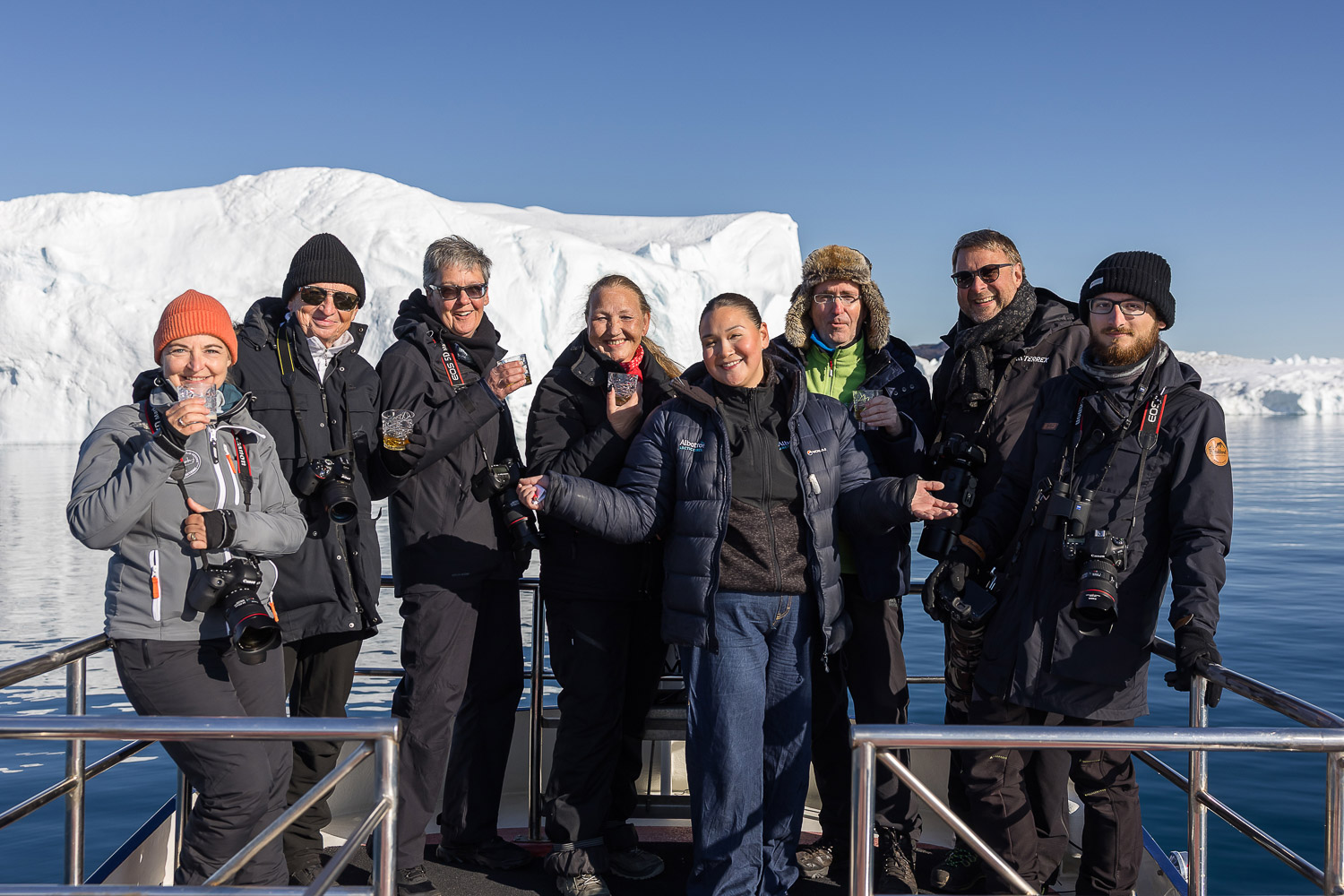 Kleine Reisegruppe auf einem Boot vor Eisbergen in der Diskobucht in Grönland