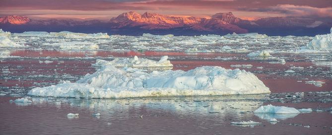 Lieblingsfoto 22/2026 mit Morgenlicht über der Disko Bucht bei Ilulissat in Westgrönland, Eisbergen, dunklem Wasser und rot beleuchteten Bergen