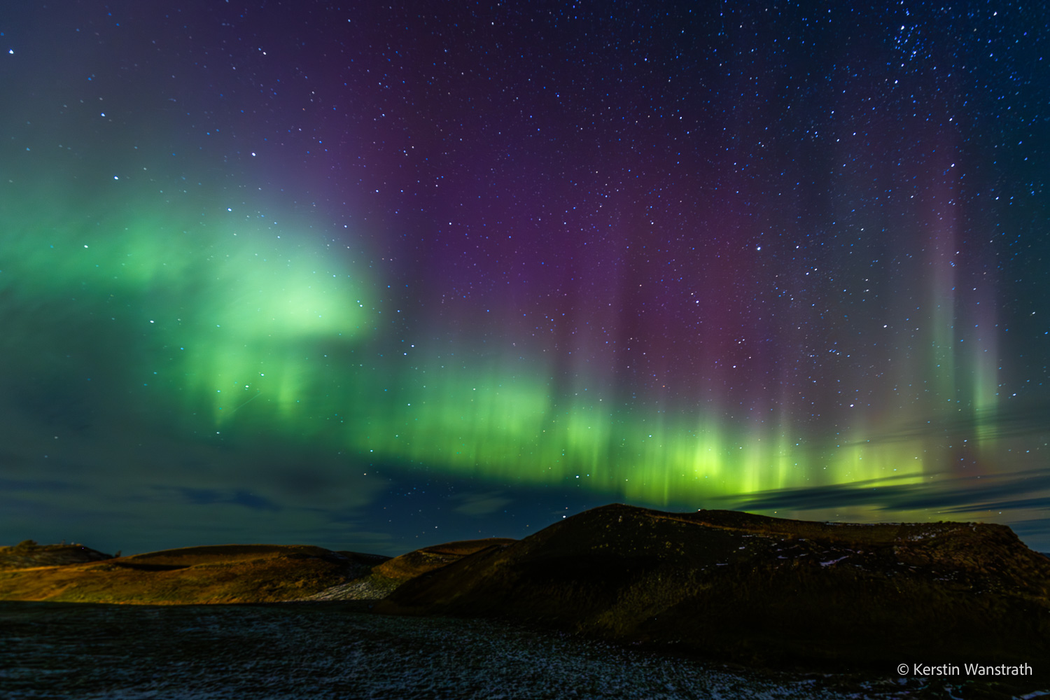 Grüne Polarlichter und Sternenhimmel über der dunklen Landschaft am Mývatn in Nordisland